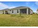 Large backyard with screened patio and grassy area at 1042 Corso Dr, Winter Haven, FL 33884