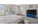 Spacious bedroom with large TV, dresser, and ensuite bathroom access at 1042 Corso Dr, Winter Haven, FL 33884