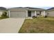 Gray house with a two-car garage and a small front porch at 1042 Corso Dr, Winter Haven, FL 33884
