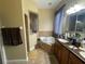 Bright bathroom features a jacuzzi tub with tile surround and a dual sink vanity with great counterspace at 1068 Stoney Creek Dr, Lakeland, FL 33811