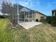 Exterior backyard shot of a screened-in pool and patio with lawn at 1068 Stoney Creek Dr, Lakeland, FL 33811