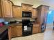 Well-equipped kitchen with wooden cabinetry, black appliances, and durable countertops at 1068 Stoney Creek Dr, Lakeland, FL 33811