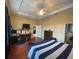 Comfortable main bedroom with ceiling fan, hardwood floors and doorway to the main bathroom at 1068 Stoney Creek Dr, Lakeland, FL 33811