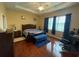 Comfortable main bedroom with hardwood floors, modern ceiling fan and plenty of natural light from the windows at 1068 Stoney Creek Dr, Lakeland, FL 33811