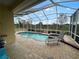 Backyard view of a screened-in pool and patio area with a serene landscape at 1068 Stoney Creek Dr, Lakeland, FL 33811