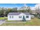 White single-wide manufactured home with green accents and a spacious yard at 13901 Hatchineha Rd, Haines City, FL 33844