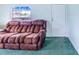 Living room featuring brown recliner and green carpet at 13901 Hatchineha Rd, Haines City, FL 33844