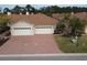 Aerial view of a two-car garage villa with a brick driveway at 1649 Linz Ct, Winter Haven, FL 33884