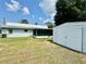 Backyard view features a shed, an air conditioning unit, and a screened-in porch at 1663 W Lake Cannon Nw Dr, Winter Haven, FL 33881