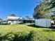 Spacious backyard with lush lawn, storage shed, and covered patio at 1663 W Lake Cannon Nw Dr, Winter Haven, FL 33881