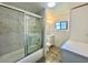 Modern bathroom with shower over bath and marble tile at 1663 W Lake Cannon Nw Dr, Winter Haven, FL 33881
