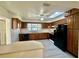 Eat-in kitchen with black appliances, wood cabinetry and modern countertop at 1663 W Lake Cannon Nw Dr, Winter Haven, FL 33881