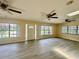 Spacious living room featuring new flooring, multiple windows, and several ceiling fans at 1663 W Lake Cannon Nw Dr, Winter Haven, FL 33881