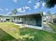 A view showcasing the home's screened-in porch, well-maintained lawn, and exterior architecture at 1663 W Lake Cannon Nw Dr, Winter Haven, FL 33881