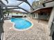 Inviting kidney-shaped pool with screened enclosure and brick paver deck at 2024 Kapree Ct, Winter Haven, FL 33884