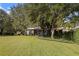 Landscaped backyard with lush lawn and partial home view at 2300 N Scenic Hwy # 37, Lake Wales, FL 33853