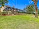 Landscaped backyard with lush lawn and a screened pool enclosure at 2683 Wyndsor Oaks Way, Winter Haven, FL 33884