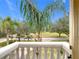 Enjoy serene views from this balcony overlooking lush greenery and a tree-lined street at 2683 Wyndsor Oaks Way, Winter Haven, FL 33884