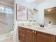 Elegant bathroom features a walk-in shower, vanity with drawers, and neutral tile at 2683 Wyndsor Oaks Way, Winter Haven, FL 33884