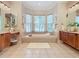 Luxurious bathroom featuring a large soaking tub and dual vanities at 2683 Wyndsor Oaks Way, Winter Haven, FL 33884