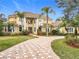 Two-story house with tile roof, palm trees, and a paved driveway at 2683 Wyndsor Oaks Way, Winter Haven, FL 33884