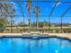 Inviting pool area with a screened enclosure, water feature, and serene view at 2683 Wyndsor Oaks Way, Winter Haven, FL 33884