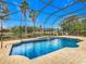 Relaxing screened-in pool with a fountain feature in a beautifully landscaped backyard at 2683 Wyndsor Oaks Way, Winter Haven, FL 33884