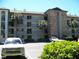Multi-level condo building showcasing tropical landscaping and ample parking spaces for residents and guests at 333 Lake Howard Nw Dr # 202-A, Winter Haven, FL 33880