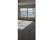 Bright living room features new gray carpet and a picture window displaying scenic outdoor views at 333 Lake Howard Nw Dr # 202-A, Winter Haven, FL 33880