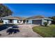 House front view, featuring a two-car garage and landscaping at 3340 Crump Rd, Winter Haven, FL 33881