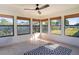 Bright sunroom with tile flooring, ceiling fan, and multiple windows offering backyard views at 3340 Crump Rd, Winter Haven, FL 33881