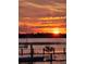 Stunning sunset over calm lake waters with small boat and dock at 3340 Crump Rd, Winter Haven, FL 33881