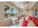 Relaxing sunroom with red couch and view of backyard at 340 Lake Suzanne Dr, Lake Wales, FL 33859