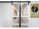 Stylish bathroom entry with glass barn doors and gallery wall at 3457 Raleigh Dr, Winter Haven, FL 33884