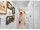 A charming hallway with framed artwork leading to a bathroom at 3457 Raleigh Dr, Winter Haven, FL 33884