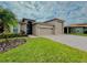 House exterior featuring a two-car garage and manicured lawn at 3834 Litchfield Loop, Lake Wales, FL 33859