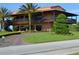 Two-story golf clubhouse with palm trees and paved driveway at 3834 Litchfield Loop, Lake Wales, FL 33859