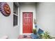 Inviting front entry with red door, plants, and patio chairs at 3946 Bedford Ave, Winter Haven, FL 33884