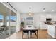 Bright dining area with sliding glass doors to the patio, a modern pendant light, and an adjacent kitchen at 425 Riders Loop, Auburndale, FL 33823