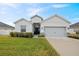 Charming home featuring a two-car garage, a well-manicured lawn, and inviting front entrance at 425 Riders Loop, Auburndale, FL 33823