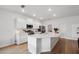 Bright white kitchen features a large central island, modern appliances, and wood-look flooring at 425 Riders Loop, Auburndale, FL 33823