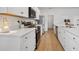 Bright kitchen with white cabinets, stainless appliances, long countertops, and wood-look flooring at 425 Riders Loop, Auburndale, FL 33823