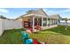 Spacious backyard with a screened porch, patio furniture, and lush grass at 426 Allison Ave, Davenport, FL 33897