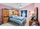 Relaxing bedroom with pink walls, ceiling fan, and built-in wooden headboard at 426 Allison Ave, Davenport, FL 33897