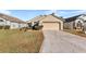 Tan one-story house with a two-car garage and well-maintained lawn at 426 Allison Ave, Davenport, FL 33897