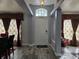 Entryway with white door, grey tile floor, and burgundy curtains at 437 Grand Reserve Dr, Davenport, FL 33837
