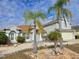 Two-story house with palm trees, landscaping, and a beige exterior at 437 Grand Reserve Dr, Davenport, FL 33837