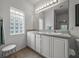 Double vanity bathroom with a large mirror and a glass block window at 4505 Back Nine Dr, Winter Haven, FL 33884