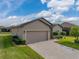 Tan one-story house with two-car garage and landscaped yard on a sunny day at 4505 Back Nine Dr, Winter Haven, FL 33884