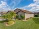 Tan one story house with two-car garage and lush landscaping, sunny day at 4505 Back Nine Dr, Winter Haven, FL 33884